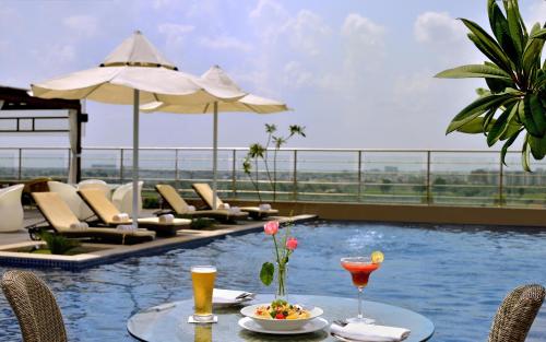 a table with a plate of food and drinks on a pool at Radisson Blu Jaipur in Jaipur