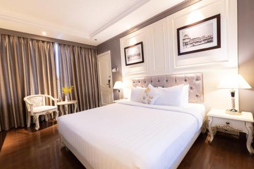 a bedroom with a large white bed and a window at Silverland Jolie Hotel in Ho Chi Minh City