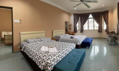 Un dormitorio con dos camas y un sofá azul. en Dino House, en Taiping