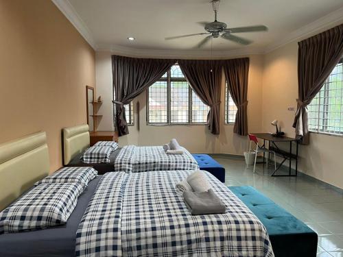 a bedroom with two beds and a ceiling fan at Dino House in Taiping