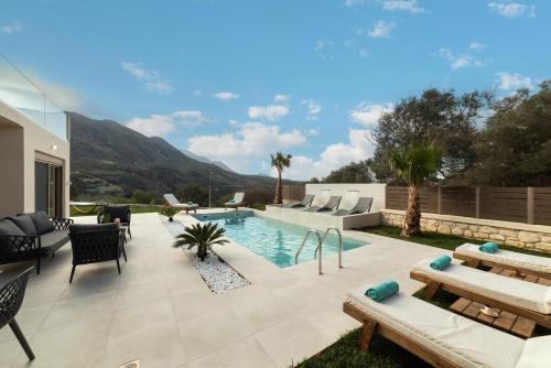 a backyard with a swimming pool and a patio with furniture at Villa Silentium Olia by PosarelliVillas in Aryiroúpolis