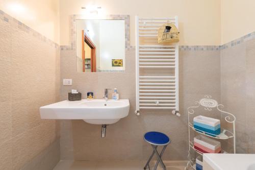 a bathroom with a sink and a mirror and a stool at Casa Ricale in Terra Mala