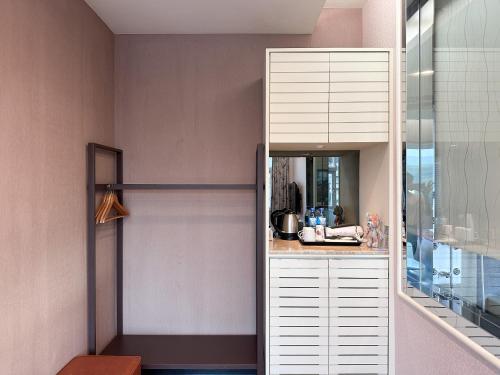 eine Küche mit weißen Schränken und einem Spiegel in der Unterkunft Li Quan Hot Spring Resort in Stadtteil Baihe District