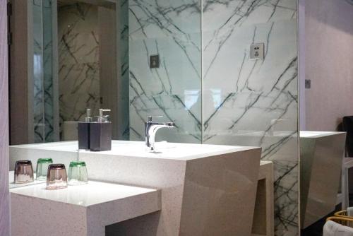 a bathroom with a sink and a mirror at Paco Hotel Tianhe Coach Terminal Metro Satation Guangzhou-Free Shuttle Bus for Canton Fair in Guangzhou