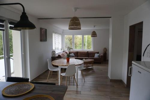cocina y sala de estar con mesa y sillas en Le bord de Sarre meublé 3 étoiles en Sarreguemines