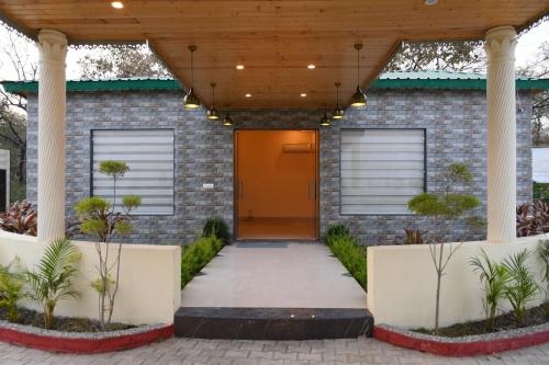 uma porta da frente de uma casa de tijolos com uma porta laranja em Vasant Corbett Resort em Ramnagar