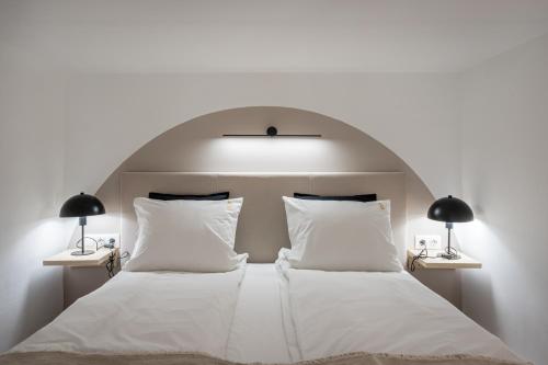 sypialnia z dużym białym łóżkiem z 2 lampami w obiekcie KL35- Boutique Apartments, Best Location. By BQA w Budapeszcie