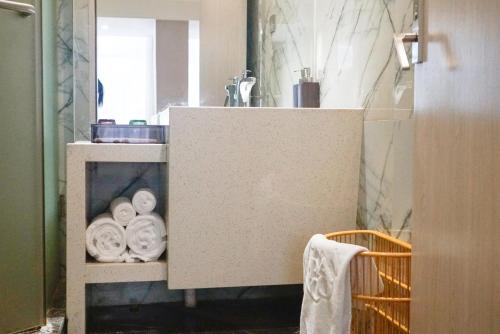 a bathroom with a sink and a counter with towels at Paco Hotel Tianhe Coach Terminal Metro Satation Guangzhou-Free Shuttle Bus for Canton Fair in Guangzhou