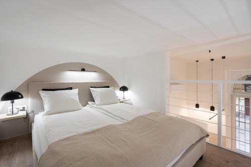 biała sypialnia z dużym łóżkiem i oknem w obiekcie KL35- Boutique Apartments, Best Location. By BQA w Budapeszcie