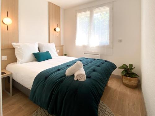 sypialnia z dużym łóżkiem z dwoma ręcznikami w obiekcie RESIDENCE SWEETLY ISATIS w mieście Mérignac