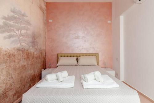 a bedroom with a bed with two white pillows at L'inchiostro di Dante in Macerata