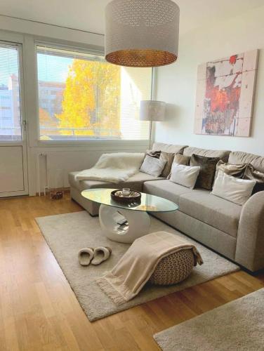 a living room with a couch and a table at 》Kaupunkikoti Kristiina - Turun ydinkeskustassa in Turku