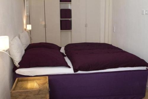 a bed with two purple pillows and a table at JM Apartments in Berlin