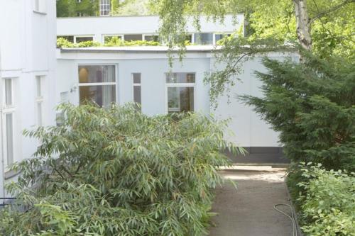 a white building with trees in front of it at JM Apartments in Berlin