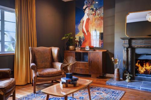 a living room with a chair and a fireplace at The Hawthorn Boutique Hotel in George