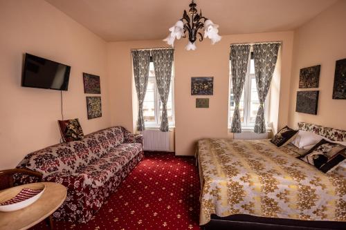 ein Wohnzimmer mit einem Bett und einem Sofa in der Unterkunft Altwienerhof Aparthotel in Wien