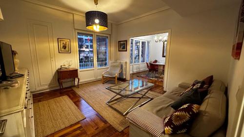 ein Wohnzimmer mit einem Sofa und einem Tisch in der Unterkunft Fantástico apartamento en el centro de Bilbao in Bilbao
