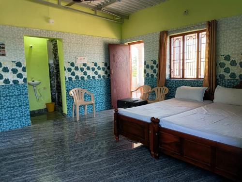 - une chambre avec un lit et une salle de bains pourvue d'un lavabo dans l'établissement Blue Leaf Residency, à Rameswaram