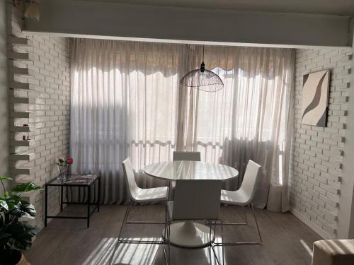 貝尼多姆的住宿－Ruzafa Beach，一间带桌子和白色椅子的用餐室
