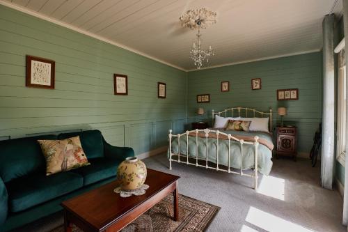 Clifton Homestead في Ranelagh: غرفة نوم بسرير واريكة وطاولة