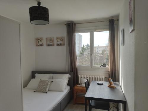Habitación pequeña con cama y ventana en La Grâce en Vaulx-en-Velin