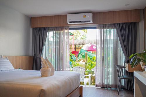 Ban Ba Ngan的住宿－นคร นอน เล่น(Nakhon Norn Len)，一间卧室设有大窗户,享有游乐场的景色
