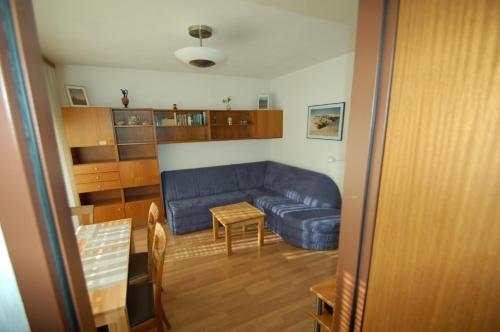 ein Wohnzimmer mit einem blauen Sofa und einem Tisch in der Unterkunft Familienappartement Talblick include Jokercard - only summer in Saalbach-Hinterglemm