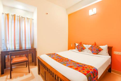 a bedroom with a bed and a desk and a chair at FabExpress Corner Courtyard - Nr Botanical Garden, Kondapur in Kondapur