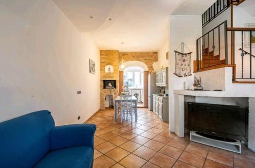 a living room with a blue couch and a kitchen at Casa Mary in Fregene