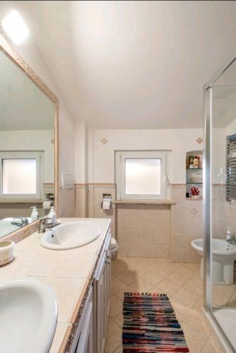 a bathroom with two sinks and a tub and a shower at Casa Mary in Fregene
