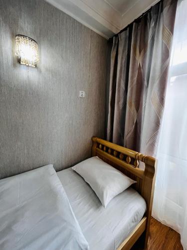 a small bedroom with two beds and a window at Khongor Guest house & Tours in Ulaanbaatar