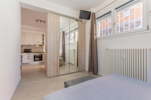 een slaapkamer met een bed en een groot raam bij San Donato Fiere Essential Apartment w/parking in Bologna