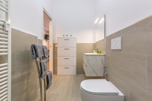 een badkamer met een wit toilet en een wastafel bij San Donato Fiere Essential Apartment w/parking in Bologna
