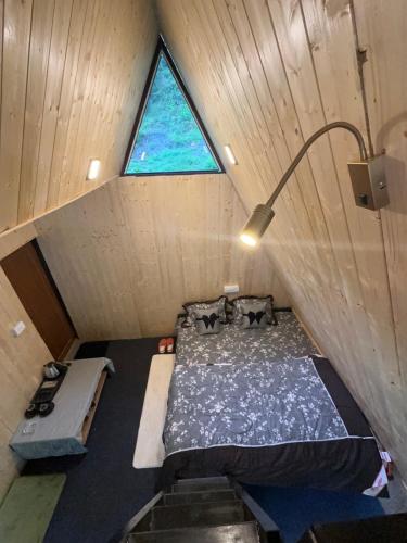 an attic room with a bed and a window at Sunshine Cafe & Cottage Riverside in Shoja