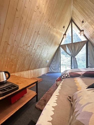 a room with a bed and a stove in a room at Sunshine Cafe & Cottage Riverside in Shoja