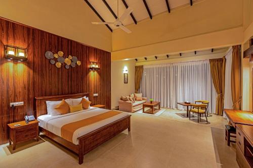 Birds Resort Hambantota في هامبانتوتا: غرفة نوم مع سرير وغرفة معيشة
