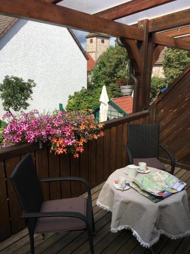 a table and chairs on a deck with flowers at Gasthaus Kirchhoff in Beverungen