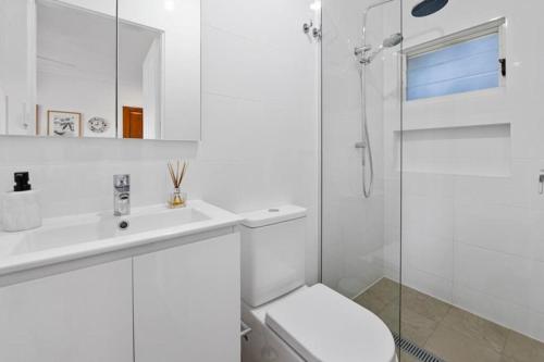 a bathroom with a toilet and a sink and a shower at Cosy Cottage Above the Hawkesbury w/ Jetty in Mooney Mooney