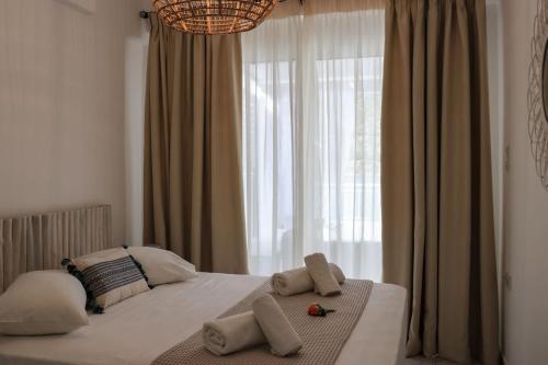 a bedroom with a bed with a large window at Grand Bleu Apartments & Villas in Ermioni