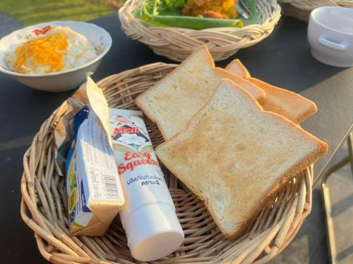 a basket filled with toast and chips and a basket of food at Cana Garden House 1 โฮมสเตย์ in Ban Khok