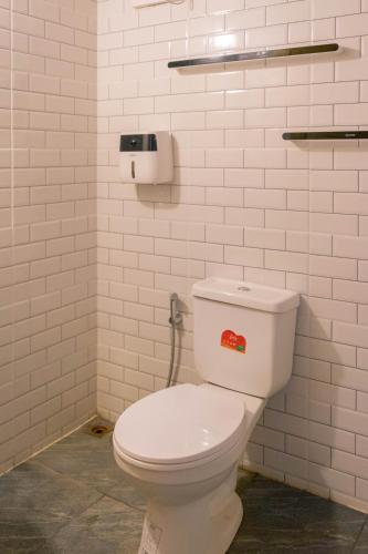 a bathroom with a white toilet with a sticker on it at Cana Garden House 1 โฮมสเตย์ in Ban Khok