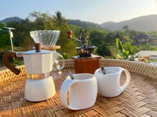 a table with two coffee mugs and a blender at Cana Garden House 1 โฮมสเตย์ in Ban Khok