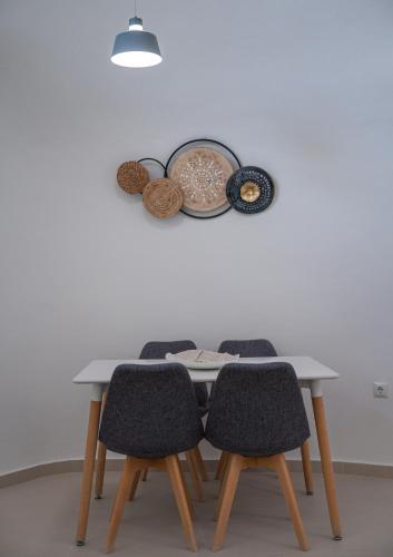 a table with four chairs and a plate on the wall at Santoterra Antigua Suites in Karterados