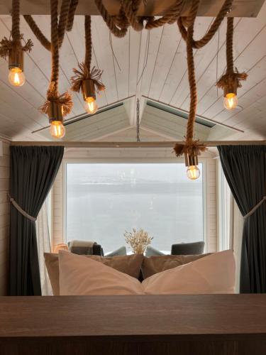 salon z kanapą i dużym oknem w obiekcie Norwegian Wild w mieście Brygghaugen