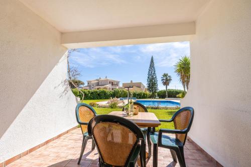 a patio with a table and chairs and a view of a house at Apartment Henry Matisse, swimming pool in Sagres