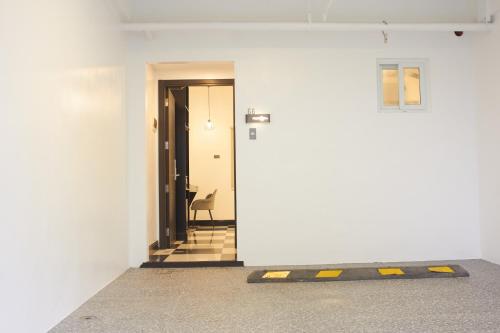 a hallway with a white wall and a door at The Blu Hotel in Baranghauon