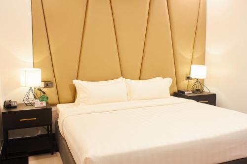 a bedroom with a large white bed with two lamps at The Blu Hotel in Baranghauon