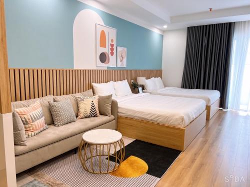 a living room with a couch and a bed at TMS Beachfront Apartment Quy Nhon Bay in Quy Nhon