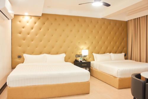 a bedroom with two beds and a large headboard at The Blu Hotel in Baranghauon