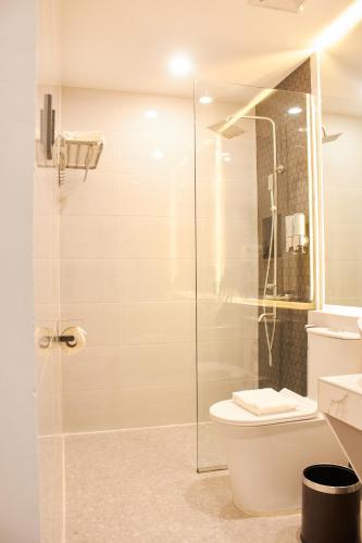 a bathroom with a toilet and a glass shower at The Blu Hotel in Baranghauon